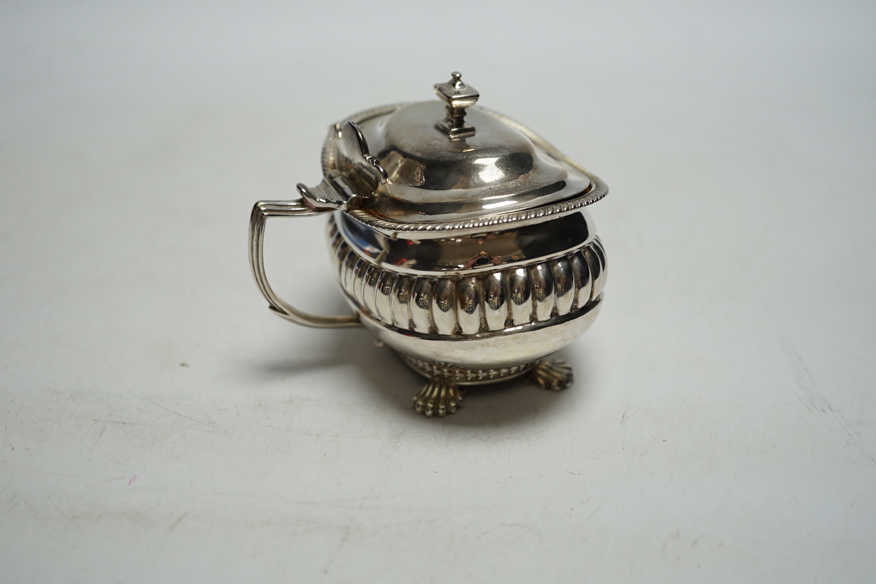 A George III demi fluted silver lidded mustard pot, London 1811 by Alexander Hewat?, length 9cm.